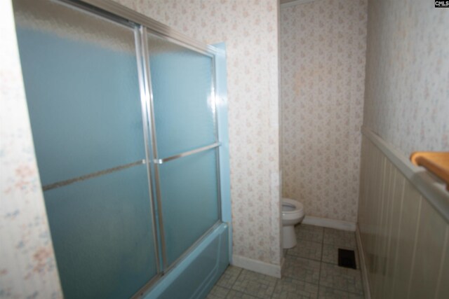 5199 Bethune Rd, Kershaw, SC 29067 - bathroom featuring wallpapered walls, tile patterned floors, toilet, baseboards, and shower / bath combination with glass door