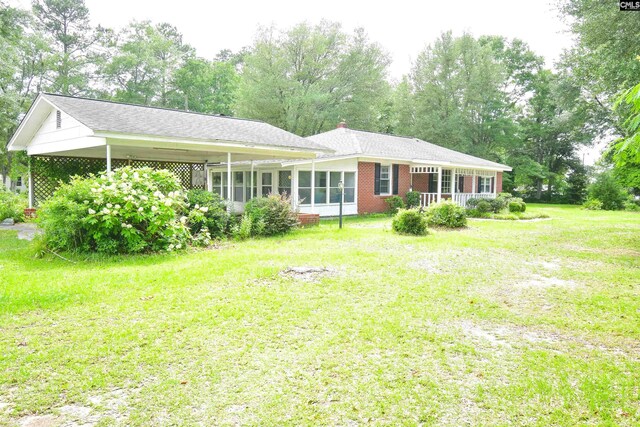 5199 Bethune Rd, Kershaw, SC 29067 - rear view of property with a lawn, a sunroom, brick siding, and view of wooded area