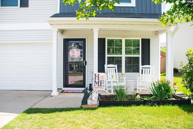 268 Drooping Leaf Rd, Lexington, SC 29072 - view of exterior entry featuring a porch, a garage, board and batten siding, concrete driveway, and a yard