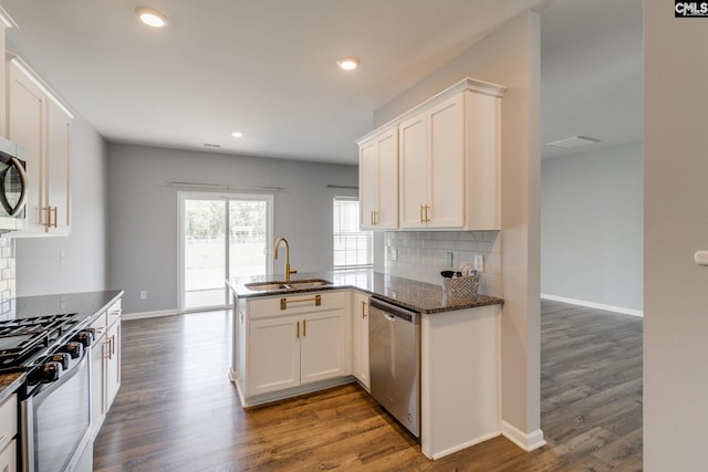 724 Channing Creek Ln, Lexington, SC 29072 - kitchen with a sink, appliances with stainless steel finishes, backsplash, a peninsula, and dark stone counters