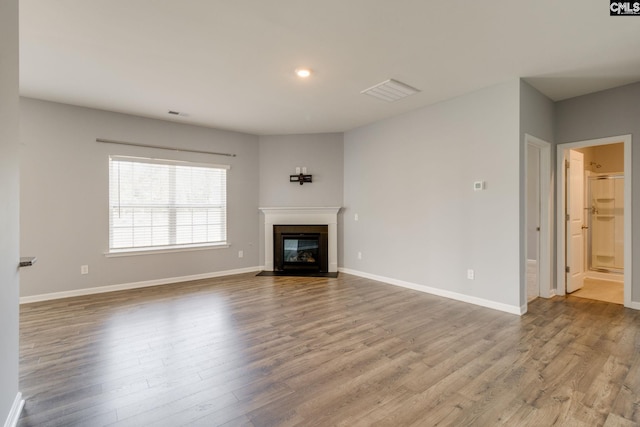 724 Channing Creek Ln, Lexington, SC 29072 - unfurnished living room with wood finished floors, a fireplace with flush hearth, baseboards, and recessed lighting