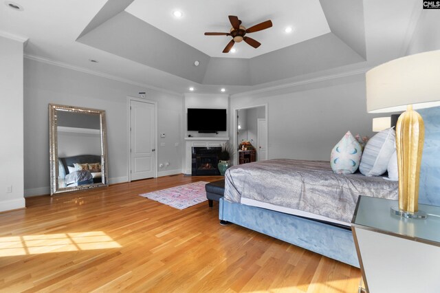 279 Canterwood Rd, Irmo, SC 29063 - bedroom with crown molding, a tray ceiling, light wood-style floors, baseboards, and a lit fireplace