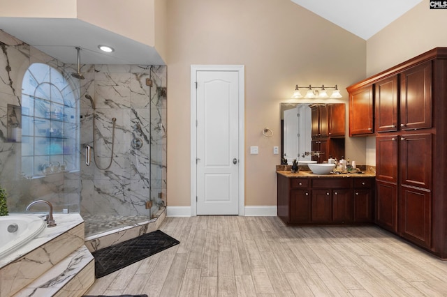 279 Canterwood Rd, Irmo, SC 29063 - full bathroom with high vaulted ceiling, a marble finish shower, a garden tub, vanity, and wood finished floors