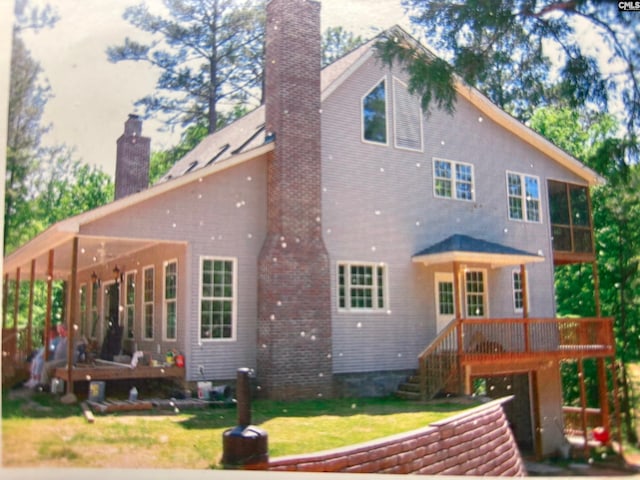 1225 Wateree Rd, Winnsboro, SC 29180 - back of property featuring a chimney, a sunroom, a deck, and a yard