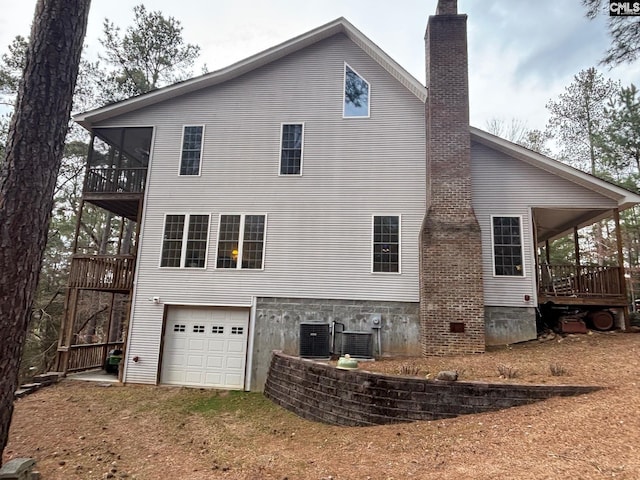 1225 Wateree Rd, Winnsboro, SC 29180 - back of house featuring a garage, central air condition unit, a chimney, and driveway