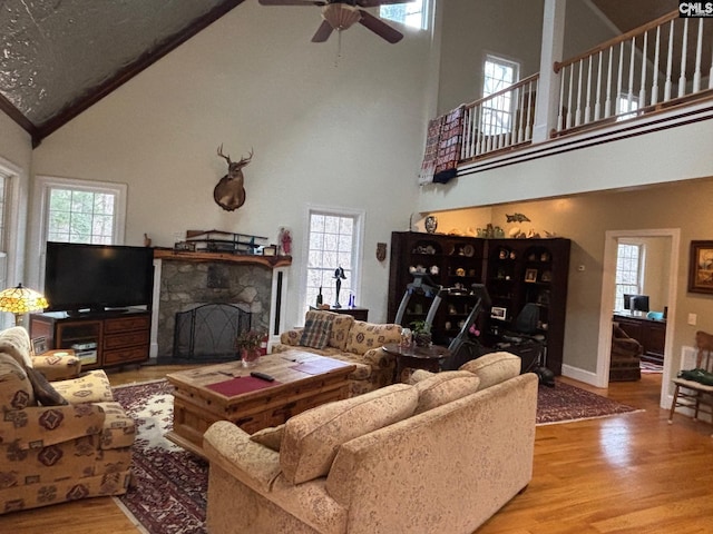 1225 Wateree Rd, Winnsboro, SC 29180 - living area featuring high vaulted ceiling, wood finished floors, plenty of natural light, a ceiling fan, and a stone fireplace