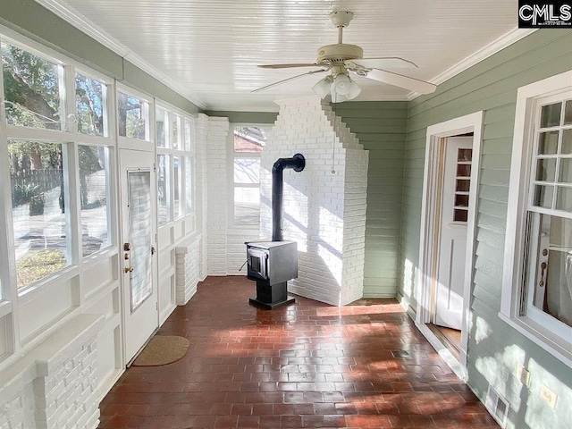 2825 Pruitt Dr, Columbia, SC 29204 - unfurnished sunroom featuring a wood stove, crown molding, brick floors, wooden walls, and french doors