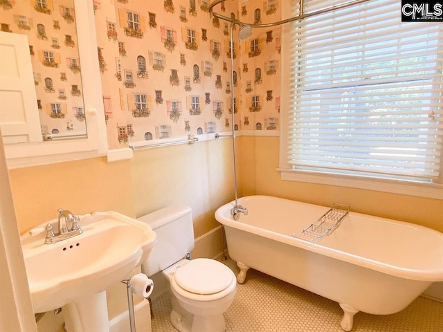 2825 Pruitt Dr, Columbia, SC 29204 - full bathroom featuring a freestanding tub, toilet, tile patterned floors, baseboards, and a sink