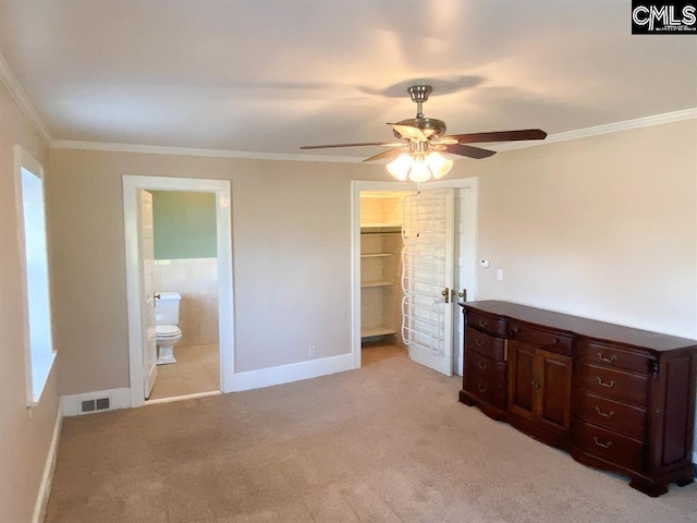 2825 Pruitt Dr, Columbia, SC 29204 - unfurnished bedroom featuring baseboards, light carpet, ornamental molding, connected bathroom, and a walk in closet