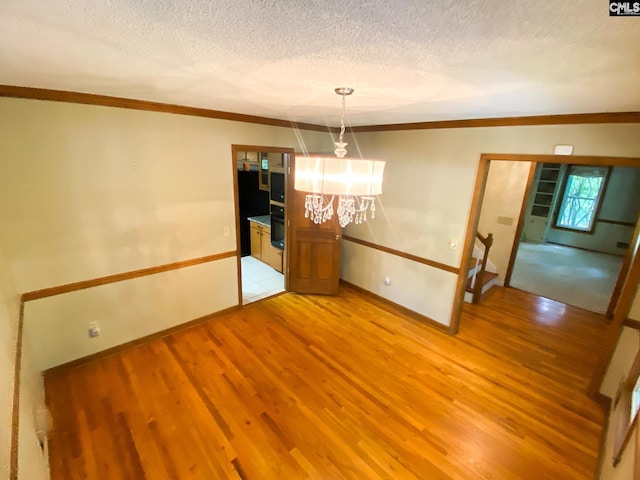 141 Runneymede Dr, Blythewood, SC 29016 - unfurnished dining area featuring baseboards, light wood-style flooring, crown molding, a textured ceiling, and a chandelier