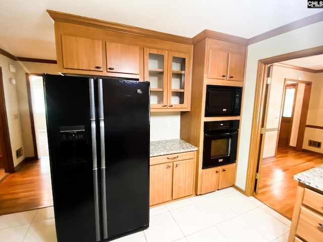 141 Runneymede Dr, Blythewood, SC 29016 - kitchen with black appliances, crown molding, glass insert cabinets, light tile patterned floors, and light stone countertops