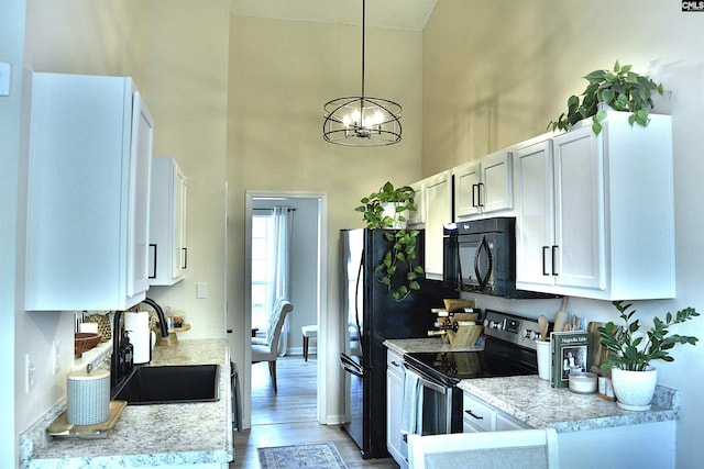 25 Elcock Cir, Irmo, SC 29063 - kitchen with black appliances, a sink, a high ceiling, light countertops, and light wood-style floors
