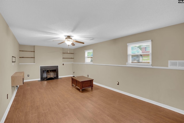 320 Trowbridge Rd, Columbia, SC 29229 - unfurnished living room with a fireplace with flush hearth, wood finished floors, a ceiling fan, baseboards, and a textured ceiling