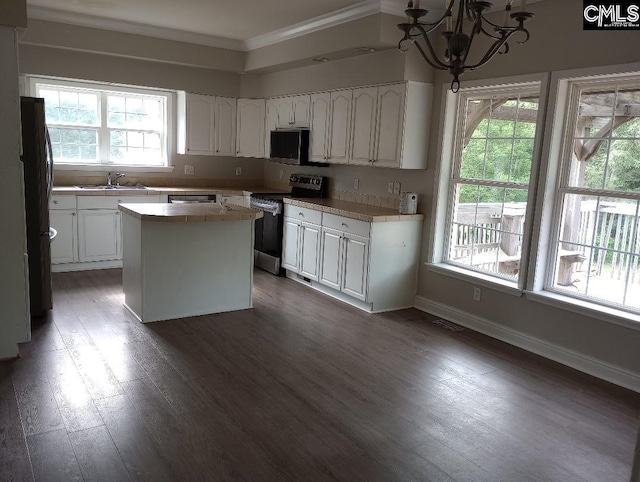 1699 Green Hill Rd, Lugoff, SC 29078 - kitchen with appliances with stainless steel finishes, a chandelier, white cabinetry, and ornamental molding