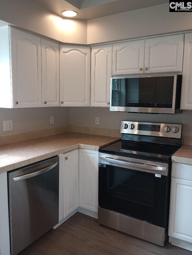 1699 Green Hill Rd, Lugoff, SC 29078 - kitchen with stainless steel appliances, white cabinets, dark wood-style floors, and light countertops
