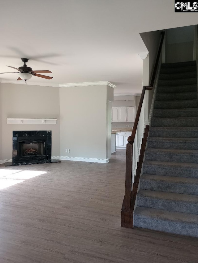 1699 Green Hill Rd, Lugoff, SC 29078 - unfurnished living room featuring stairway, crown molding, dark wood-style flooring, baseboards, and a ceiling fan