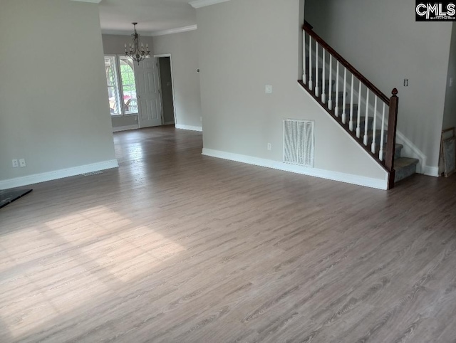1699 Green Hill Rd, Lugoff, SC 29078 - unfurnished living room featuring a chandelier, baseboards, dark wood-style flooring, stairway, and ornamental molding