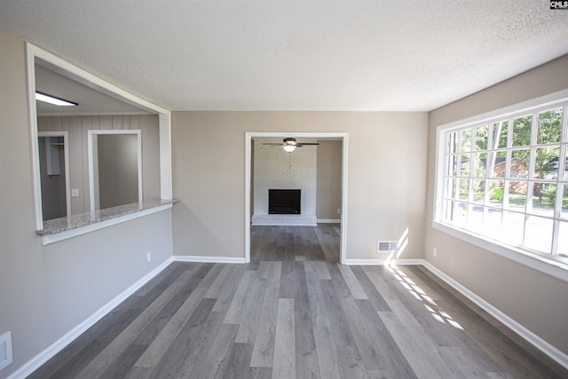 4513 Bonnie Forest Blvd, Columbia, SC 29210 - empty room featuring a textured ceiling, dark wood-style flooring, a fireplace, baseboards, and ceiling fan