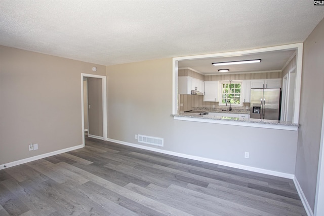 4513 Bonnie Forest Blvd, Columbia, SC 29210 - unfurnished living room featuring a sink, dark wood-style floors, baseboards, and a textured ceiling