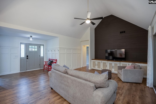 67 Ole Still Ln, Elgin, SC 29045 - living room featuring a ceiling fan, a decorative wall, wood finished floors, high vaulted ceiling, and wainscoting