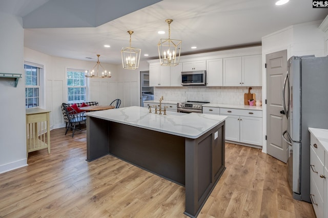 67 Ole Still Ln, Elgin, SC 29045 - kitchen featuring stainless steel appliances, a chandelier, a sink, tasteful backsplash, and white cabinetry