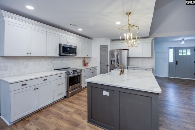 67 Ole Still Ln, Elgin, SC 29045 - kitchen with stainless steel appliances, a chandelier, wood finished floors, white cabinetry, and recessed lighting