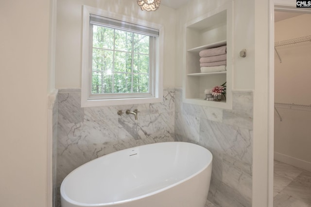 67 Ole Still Ln, Elgin, SC 29045 - full bath with a soaking tub, a walk in closet, tile walls, plenty of natural light, and wainscoting