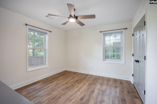 67 Ole Still Ln, Elgin, SC 29045 - unfurnished bedroom with multiple windows, wood finished floors, baseboards, and a ceiling fan