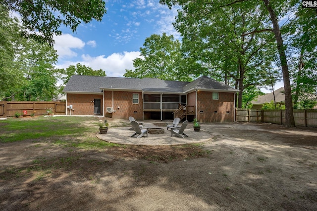 67 Ole Still Ln, Elgin, SC 29045 - rear view of house featuring an outdoor fire pit, a sunroom, a fenced backyard, and brick siding