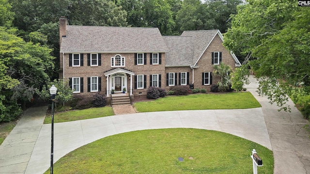 6148 Marthas Glen Rd, Columbia, SC 29209 - colonial home with a chimney, brick siding, a front yard, and a shingled roof