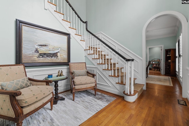 6148 Marthas Glen Rd, Columbia, SC 29209 - staircase featuring arched walkways, ornamental molding, wood finished floors, wainscoting, and a decorative wall