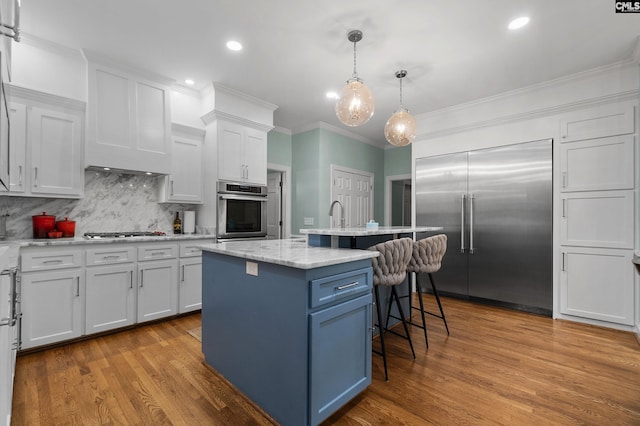 6148 Marthas Glen Rd, Columbia, SC 29209 - kitchen with stainless steel appliances, a kitchen breakfast bar, white cabinetry, backsplash, and ornamental molding