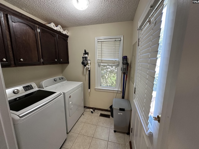 109 Cranewater Dr, Columbia, SC 29212 - washroom featuring washing machine and clothes dryer, cabinet space, a textured ceiling, light tile patterned flooring, and baseboards