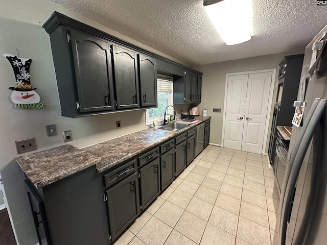 109 Cranewater Dr, Columbia, SC 29212 - kitchen with a sink, a textured ceiling, stainless steel dishwasher, dark countertops, and light tile patterned floors