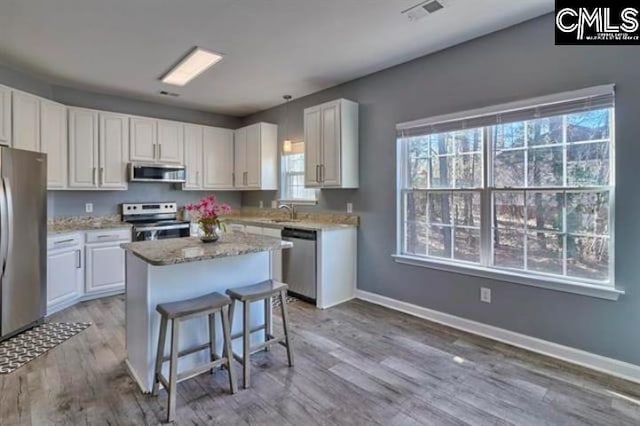 2 Alverston Ct, Irmo, SC 29063 - kitchen featuring stainless steel appliances, white cabinetry, a center island, light wood-style floors, and baseboards