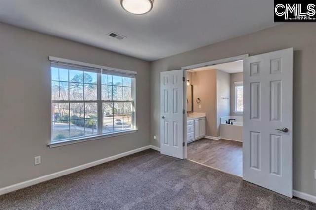 2 Alverston Ct, Irmo, SC 29063 - unfurnished bedroom featuring dark carpet, multiple windows, baseboards, and ensuite bath