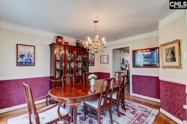 115 Chestnut Woods Ln, Columbia, SC 29212 - dining space with a wainscoted wall, a chandelier, wood finished floors, ornamental molding, and baseboards