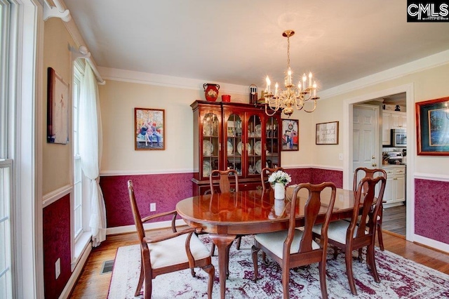 115 Chestnut Woods Ln, Columbia, SC 29212 - dining area featuring wood finished floors, a chandelier, wainscoting, baseboards, and crown molding