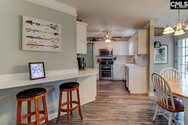 115 Chestnut Woods Ln, Columbia, SC 29212 - kitchen featuring appliances with stainless steel finishes, a sink, light countertops, dark wood-style flooring, and decorative backsplash
