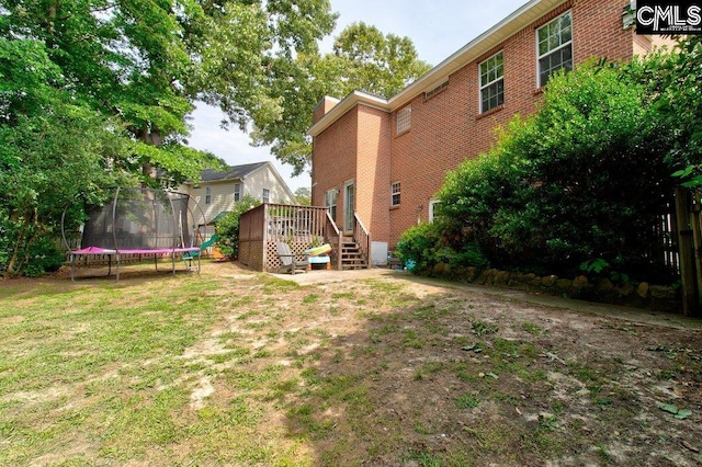 115 Chestnut Woods Ln, Columbia, SC 29212 - view of grassy yard with a trampoline and a wooden deck