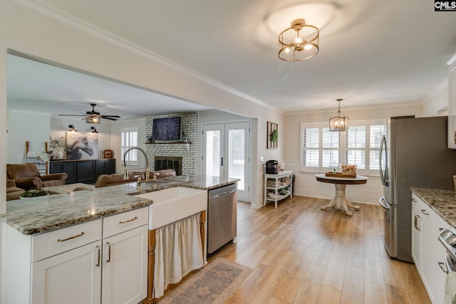 216 Jacobs Mill Pond Rd, Elgin, SC 29045 - kitchen with stainless steel appliances, a sink, open floor plan, a brick fireplace, and white cabinetry