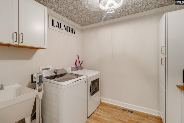 216 Jacobs Mill Pond Rd, Elgin, SC 29045 - laundry room with cabinet space, washer and clothes dryer, light wood-type flooring, baseboards, and an ornate ceiling