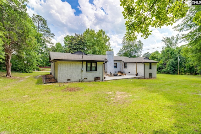 216 Jacobs Mill Pond Rd, Elgin, SC 29045 - back of property featuring a patio, a lawn, brick siding, a chimney, and crawl space