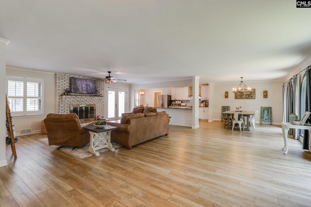216 Jacobs Mill Pond Rd, Elgin, SC 29045 - living room featuring a fireplace, a ceiling fan, a chandelier, light wood-style floors, and ornamental molding