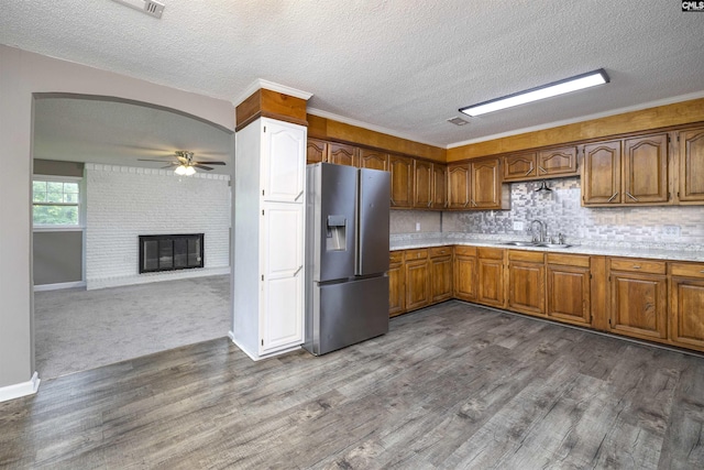 137 Wingate St, Darlington, SC 29532 - kitchen featuring stainless steel refrigerator with ice dispenser, a sink, brown cabinetry, light countertops, and dark wood finished floors