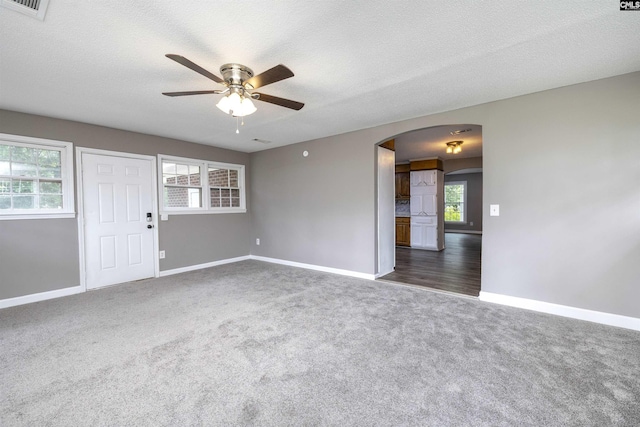 137 Wingate St, Darlington, SC 29532 - spare room featuring arched walkways, ceiling fan, dark colored carpet, baseboards, and plenty of natural light