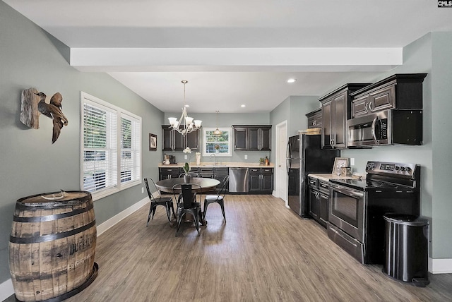 1122 Rawl Rd, Lexington, SC 29072 - kitchen featuring appliances with stainless steel finishes, light countertops, a chandelier, light wood-style flooring, and baseboards