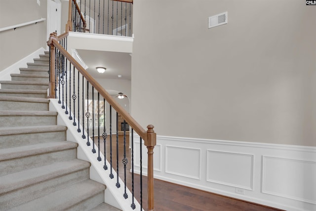 506 Moulton Way W, Columbia, SC 29170 - stairway featuring wood finished floors, a wainscoted wall, a ceiling fan, and a high ceiling