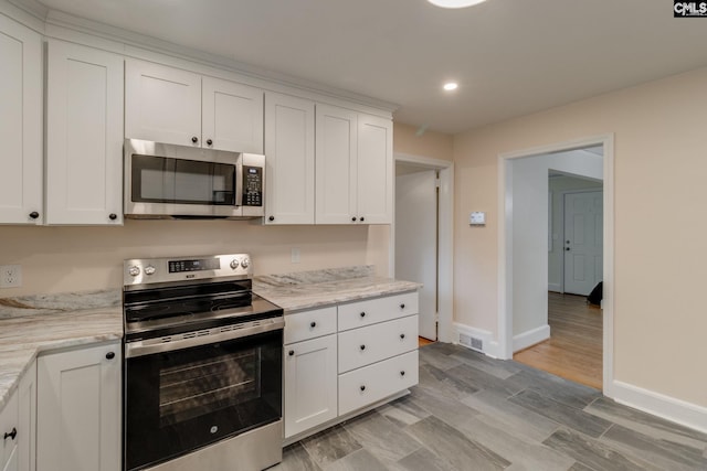 6319 Briarwood Rd, Columbia, SC 29206 - kitchen featuring appliances with stainless steel finishes, baseboards, white cabinets, recessed lighting, and light stone countertops
