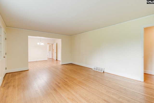 6319 Briarwood Rd, Columbia, SC 29206 - empty room featuring a chandelier, light wood-type flooring, crown molding, and baseboards